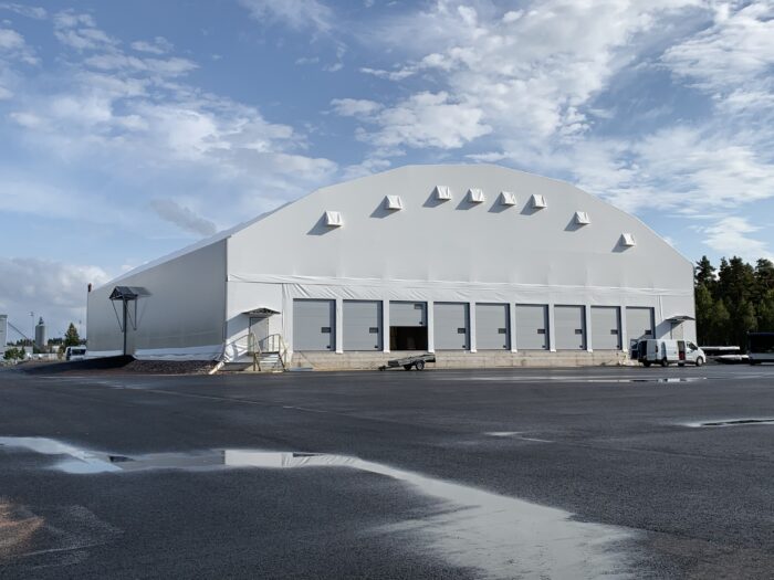 En grå hall med nio synliga lastportar (9 till på baksidan) på Sandahlsbolagens anläggning i Värnamo. Hallen fungerar som omlastningscentral / omlastningshall.