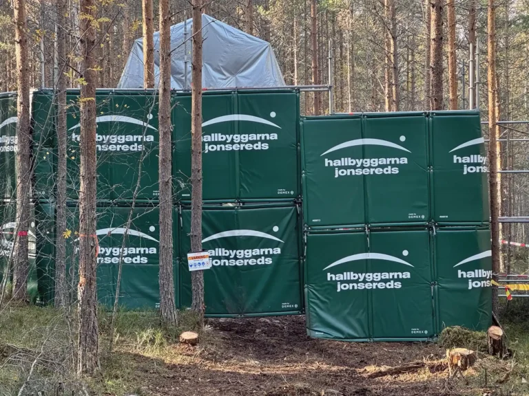 Bullermattor som täcker av och skyddar ett närliggande bostadsområde från buller under ett borrprojekt i skogen.