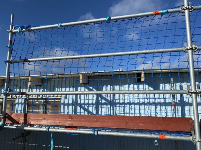 Scaffolding net for protection against falls from scaffolding. Also called guardrail netting or protective net.