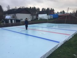 Artificially frozen ice rink/ice hockey rink at home with lines. The ice is flushed and ready