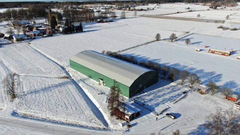 Sports hall Gullspång Arena - Sports hall in a green colour with a white roof in a winter landscape