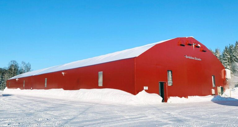 Snow covered riding hall with red facades