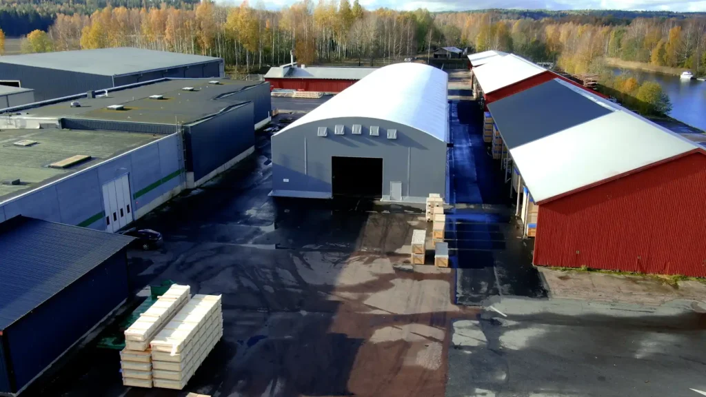 Öppning till Wermland Logistikcenters tälthall. Röda lagerbyggnader till höger och industrilokal till vänster.